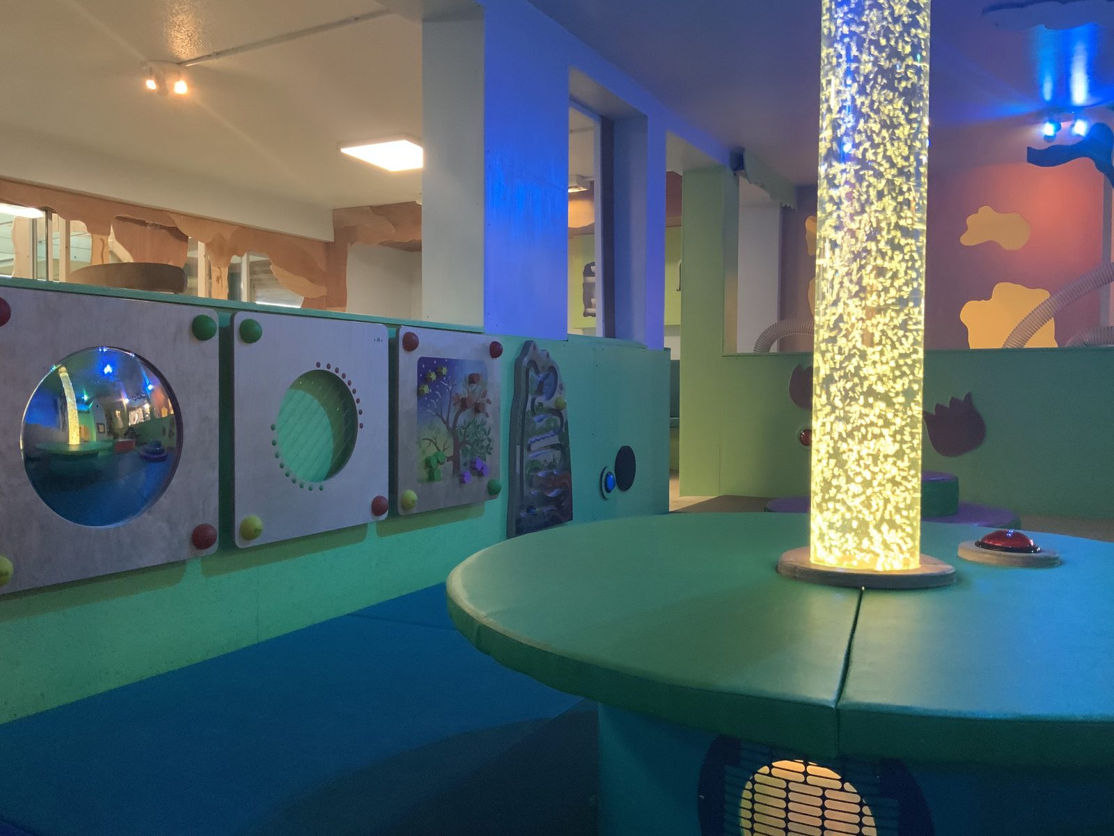 Sensory play wall and illuminated bubble tube in the indoor play area